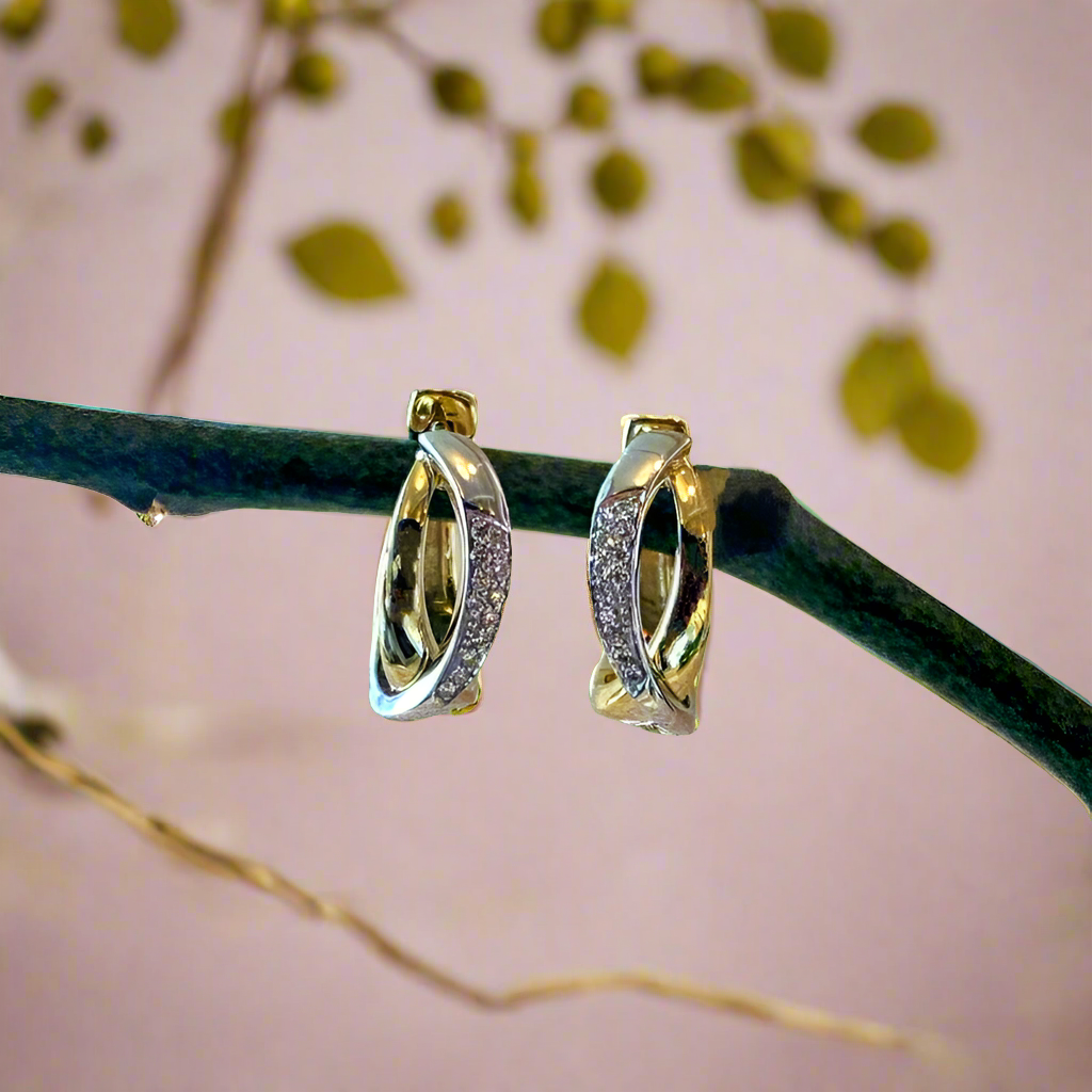 Photo of Breuning Crossover Diamond Huggies in a decorative scene, designed by , available at Plumb Gold & Plumb Silver