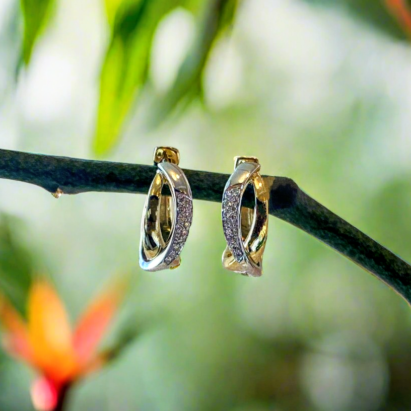 Photo of Breuning Crossover Diamond Huggies in a decorative scene, designed by , available at Plumb Gold & Plumb Silver