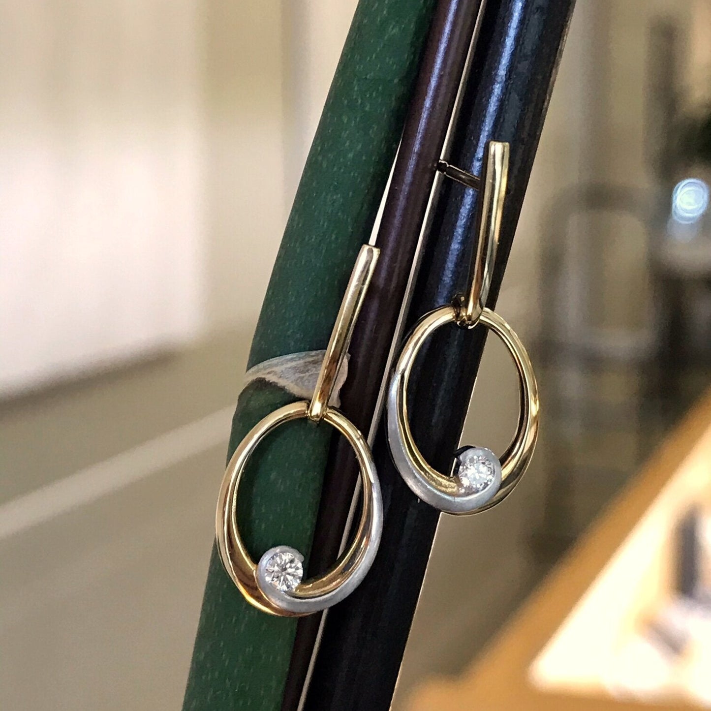 Photo of Breuning Oval Swoop Earrings in a decorative scene, designed by , available at Plumb Gold & Plumb Silver