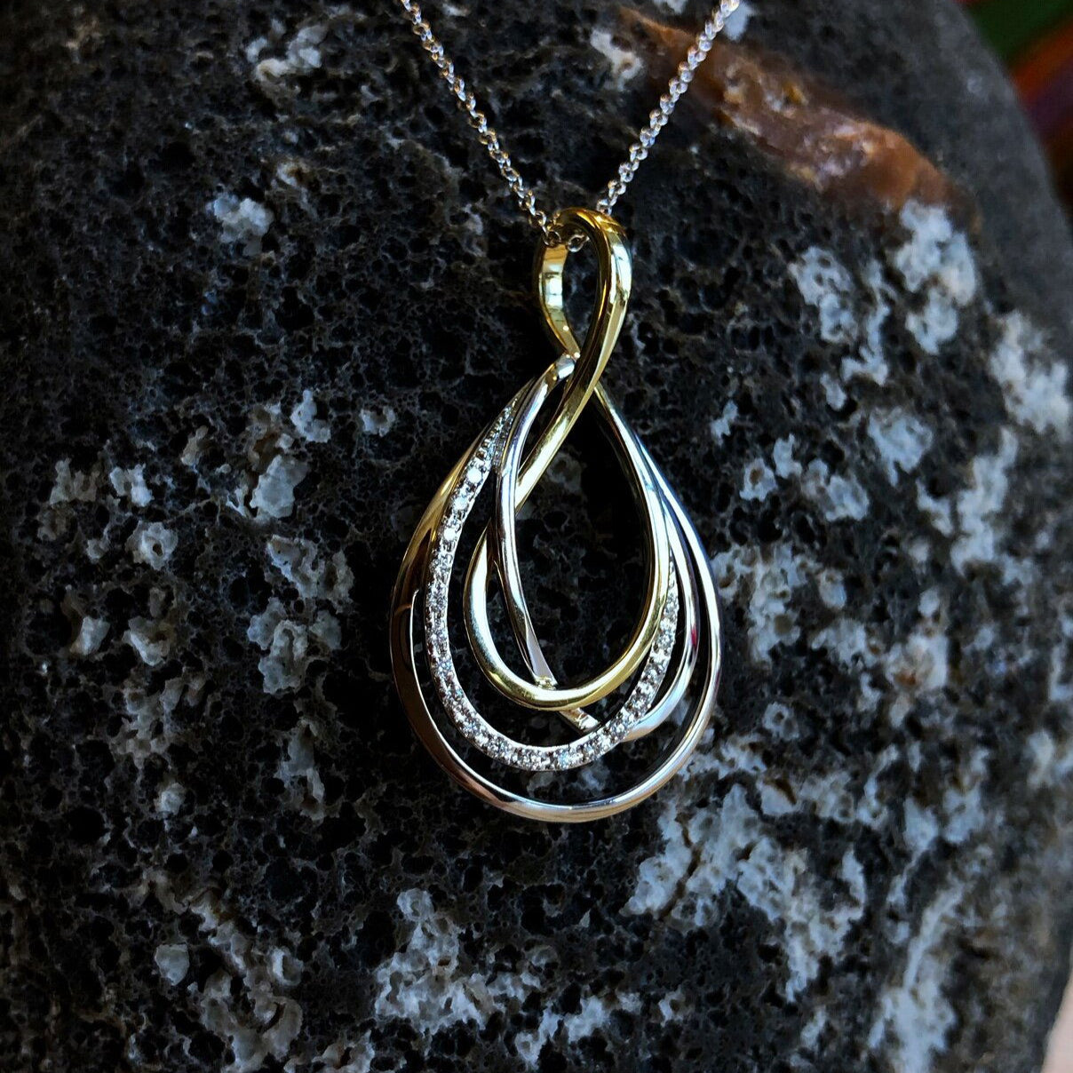 Photo of Quad Loop Diamond Pendant in a decorative scene, designed by , available at Plumb Gold & Plumb Silver