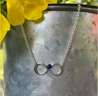 Photo of "Always" Necklace in a decorative scene, designed by , available at Plumb Gold & Plumb Silver