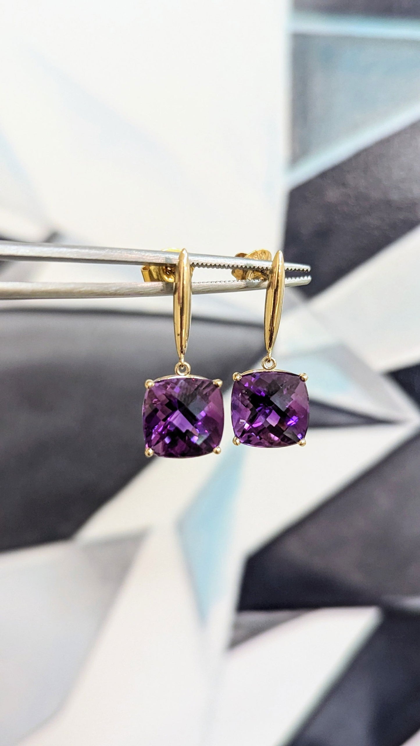 Photo of Amethyst Drop Earrings in a decorative scene, designed by , available at Plumb Gold & Plumb Silver