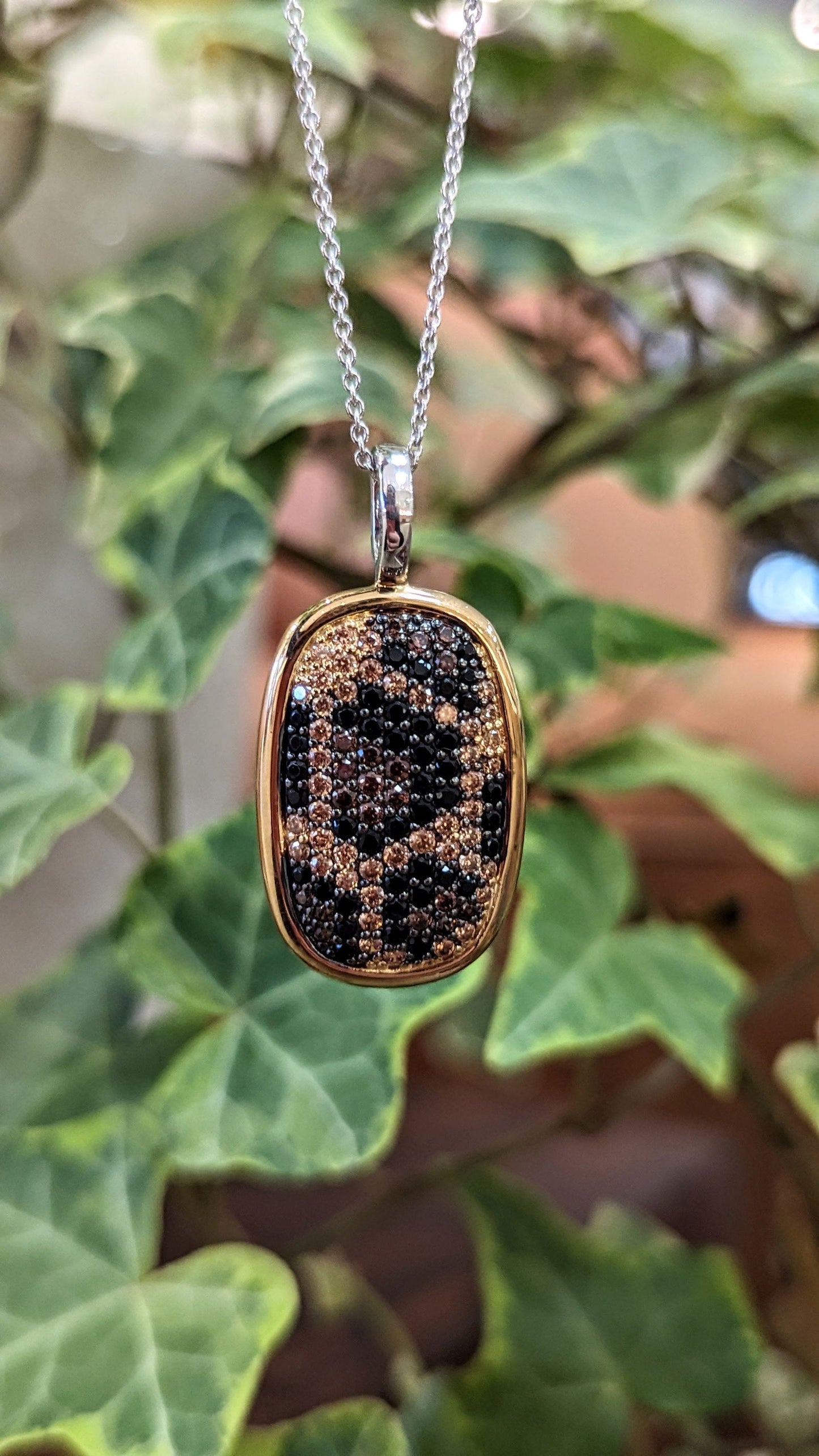 Photo of Animal Print Cubic Zirconia Pendant with Gold Plated Border in a decorative scene, designed by , available at Plumb Gold & Plumb Silver
