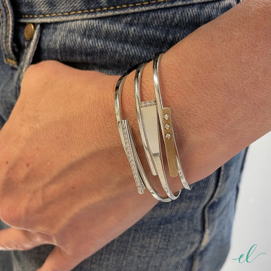 Photo of "Anticipation" Bangle in a decorative scene, designed by , available at Plumb Gold & Plumb Silver
