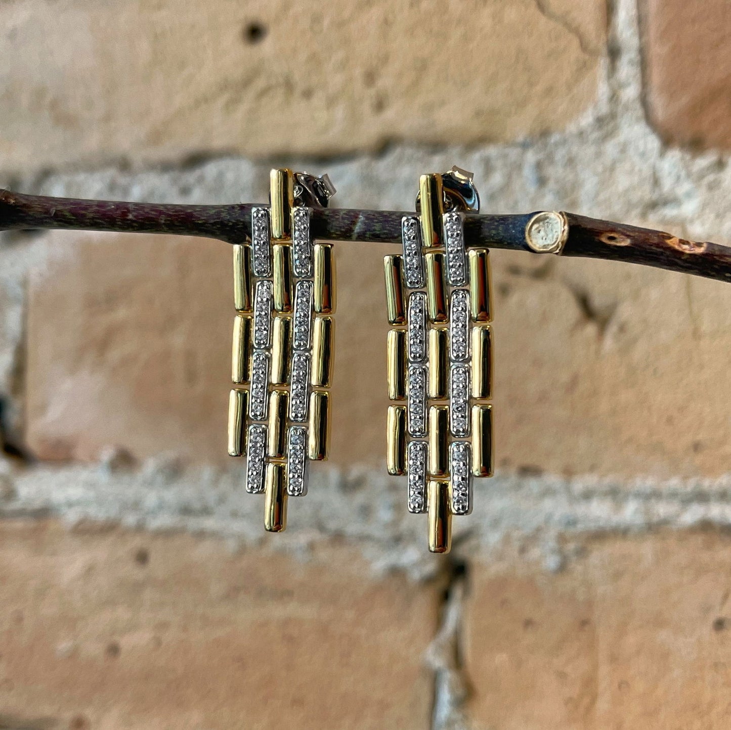 Photo of Art Deco Link Earrings in a decorative scene, designed by , available at Plumb Gold & Plumb Silver