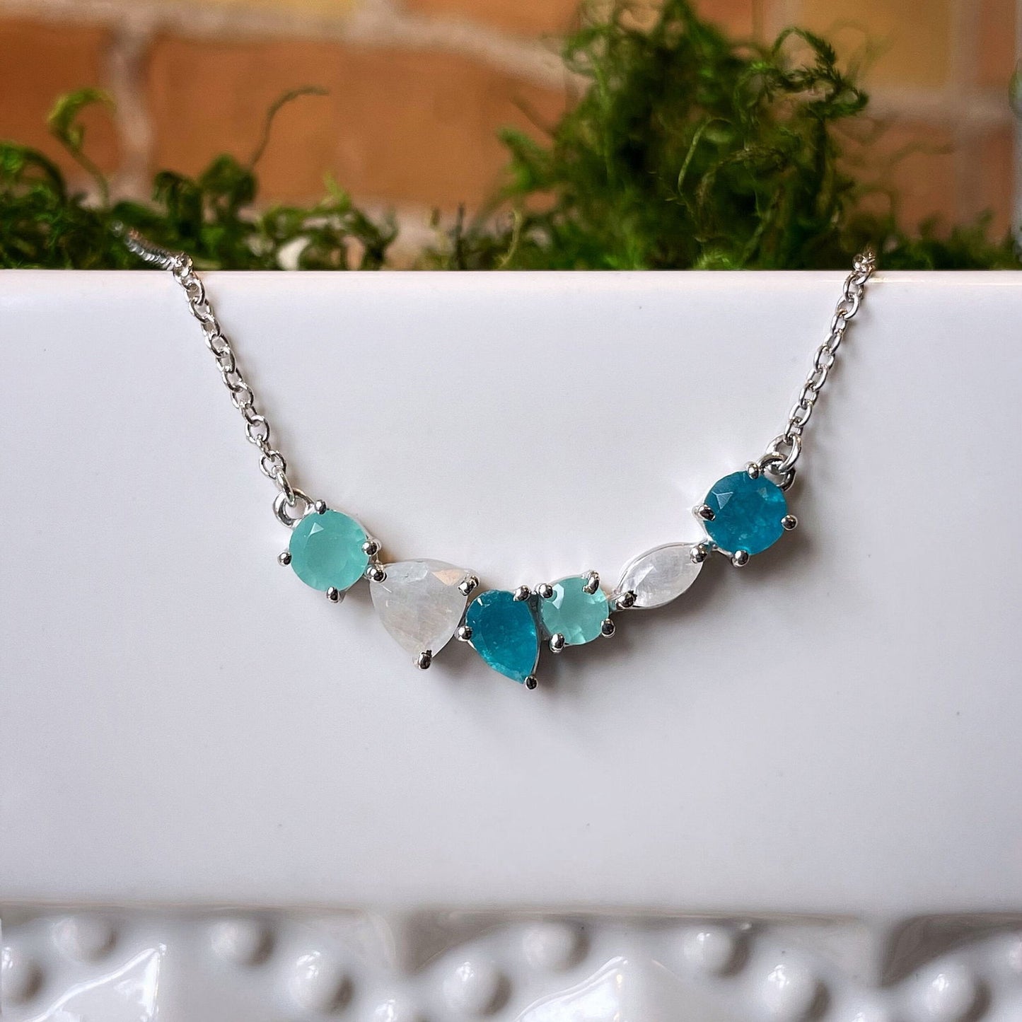 Photo of “Bella” Multi-Gem Necklace in a decorative scene, designed by , available at Plumb Gold & Plumb Silver
