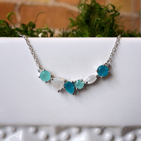 Photo of “Bella” Multi-Gem Necklace in a decorative scene, designed by , available at Plumb Gold & Plumb Silver