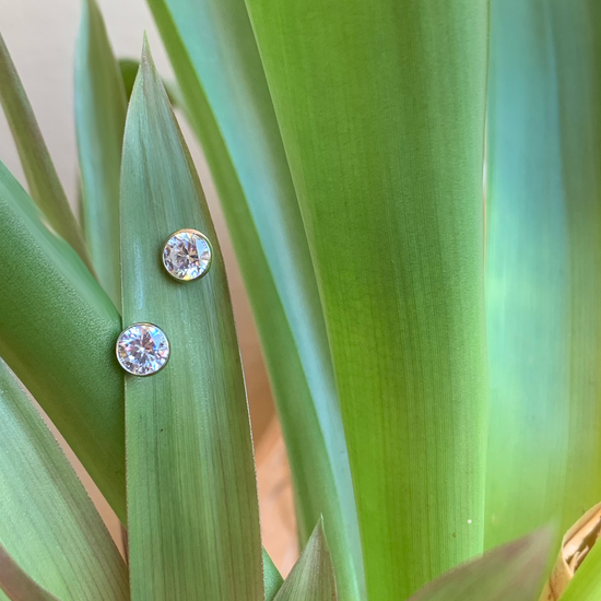 Photo of Bezel Cubic Zirconia Earrings in a decorative scene, designed by , available at Plumb Gold & Plumb Silver