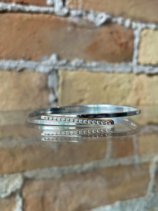 Photo of "Bling Swing" Bangle in a decorative scene, designed by , available at Plumb Gold & Plumb Silver