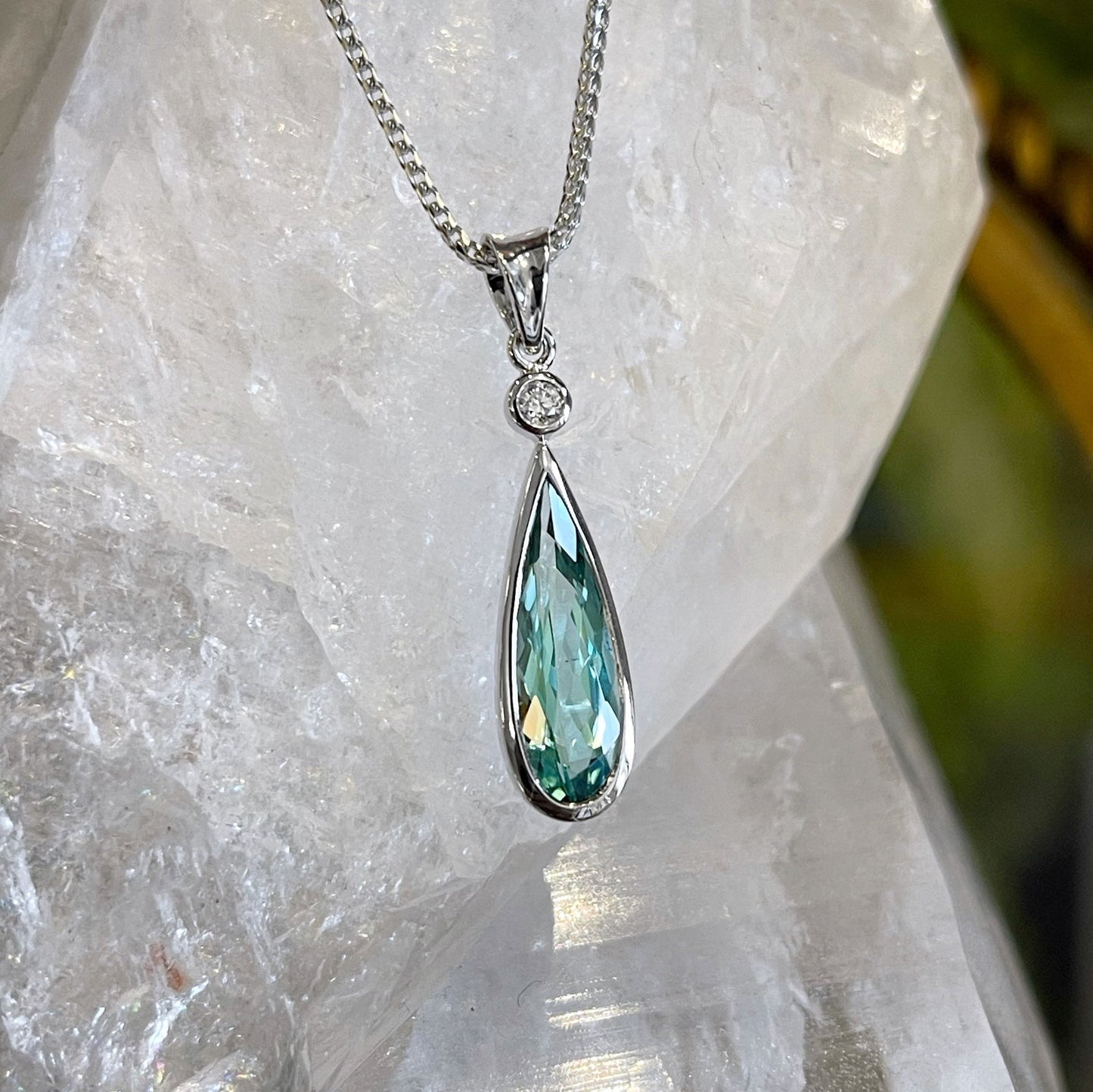 Photo of Blue-Green Tourmaline Pendant in a decorative scene, designed by , available at Plumb Gold & Plumb Silver