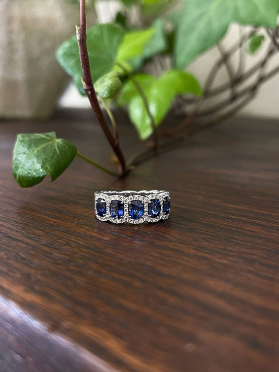 Photo of Blue Sapphire and Diamond Band in a decorative scene, designed by , available at Plumb Gold & Plumb Silver