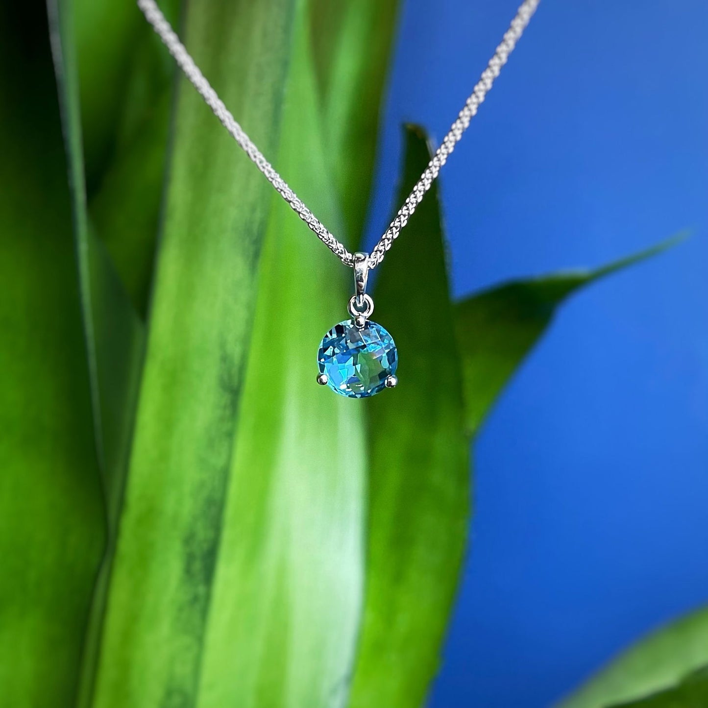 Photo of Blue Topaz Pendant in a decorative scene, designed by , available at Plumb Gold & Plumb Silver