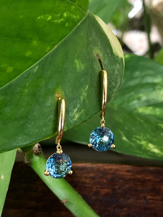 Photo of Blue Topaz Stud Dangles in a decorative scene, designed by , available at Plumb Gold & Plumb Silver