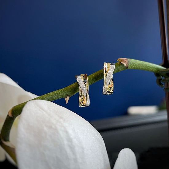 Photo of Breuning Concave Loop Earrings in a decorative scene, designed by , available at Plumb Gold & Plumb Silver