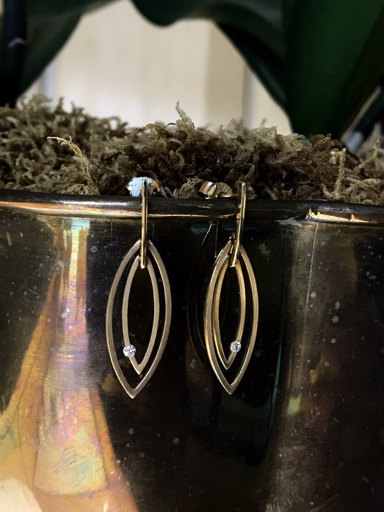 Photo of Breuning Satin Leaf Earrings in a decorative scene, designed by , available at Plumb Gold & Plumb Silver