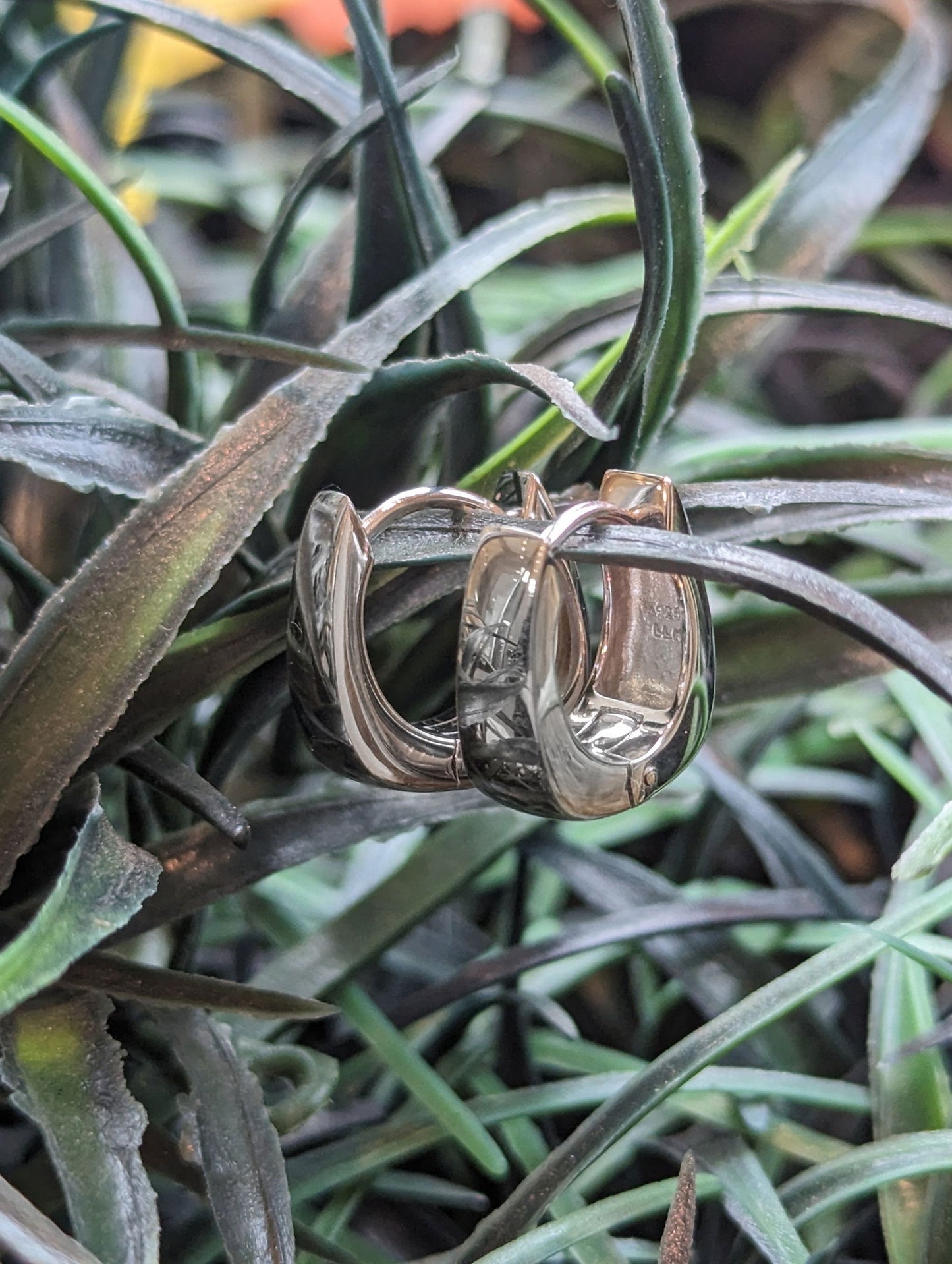 Photo of Breuning Squared Huggie Hoop Earrings in a decorative scene, designed by , available at Plumb Gold & Plumb Silver