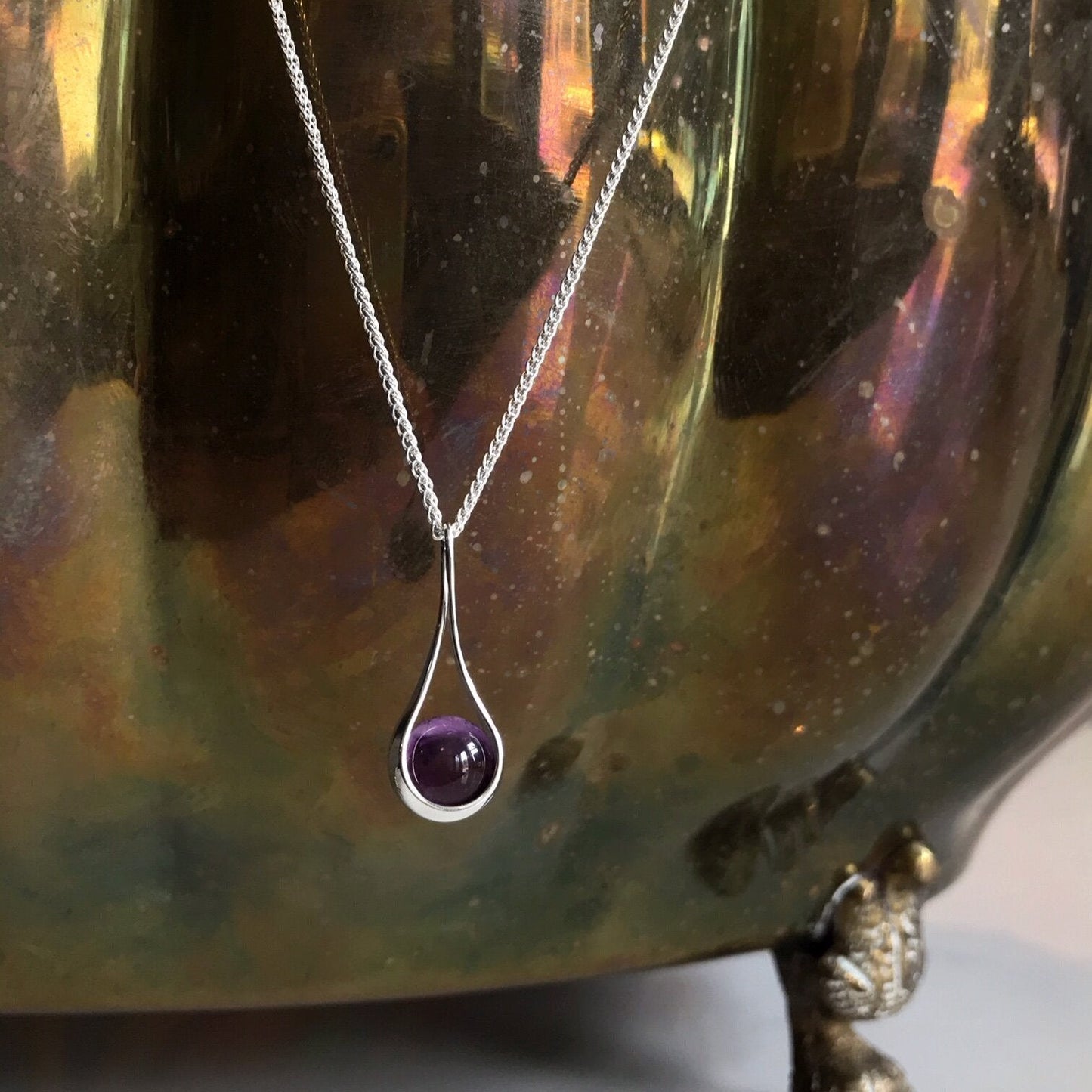Photo of "Captivating" Amethyst Necklace in a decorative scene, designed by , available at Plumb Gold & Plumb Silver
