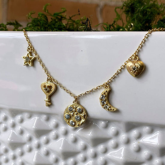 Photo of “Celestial” Blue Topaz Necklace in a decorative scene, designed by , available at Plumb Gold & Plumb Silver