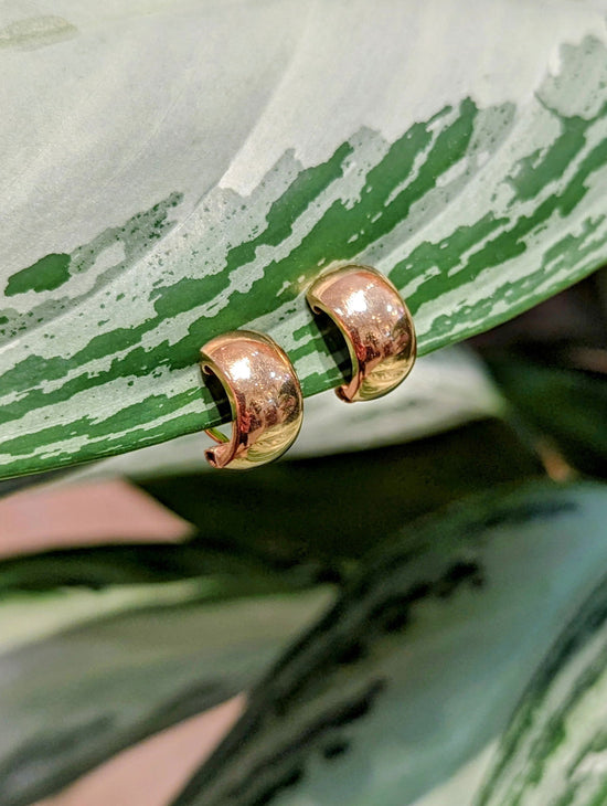 Photo of Clip Huggie Earrings in a decorative scene, designed by , available at Plumb Gold & Plumb Silver