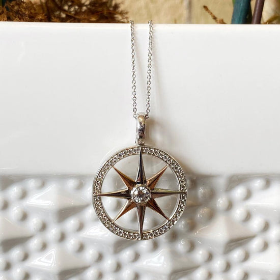 Photo of Compass Rose Pendant in a decorative scene, designed by , available at Plumb Gold & Plumb Silver