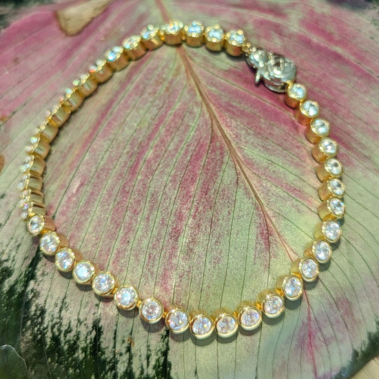 Photo of Cubic Zirconia Bezel Tennis Bracelet in a decorative scene, designed by , available at Plumb Gold & Plumb Silver