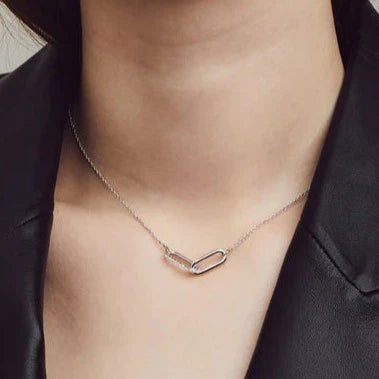 Photo of Cubic Zirconia Entwined Paperclip Necklace in a decorative scene, designed by , available at Plumb Gold & Plumb Silver