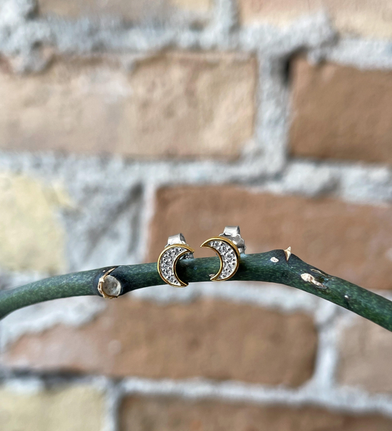 Photo of Cubic Zirconia Moon Studs in a decorative scene, designed by , available at Plumb Gold & Plumb Silver
