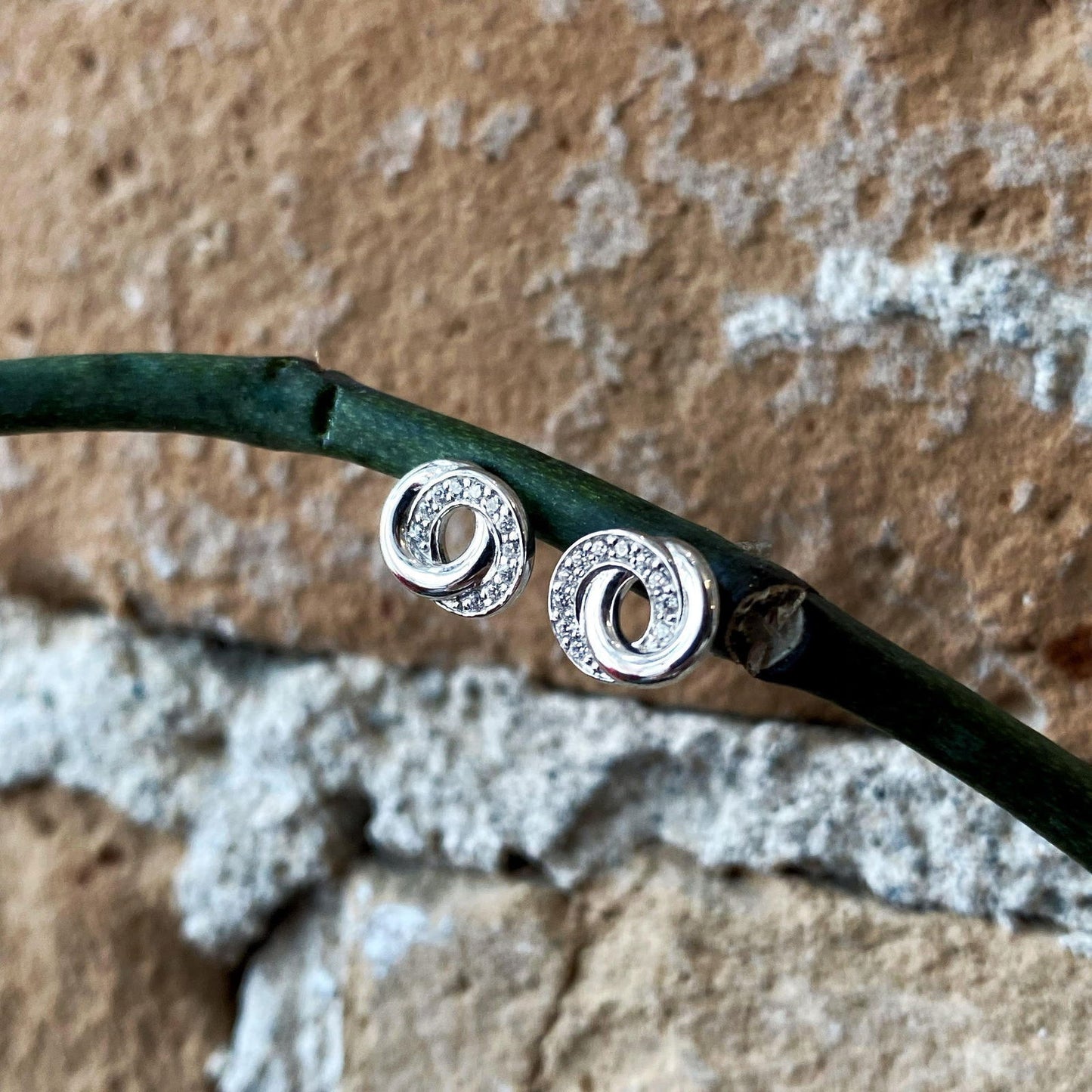 Photo of Cubic Zirconia "Swirl" Studs in a decorative scene, designed by , available at Plumb Gold & Plumb Silver