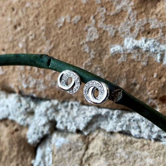 Photo of Cubic Zirconia "Swirl" Studs in a decorative scene, designed by , available at Plumb Gold & Plumb Silver