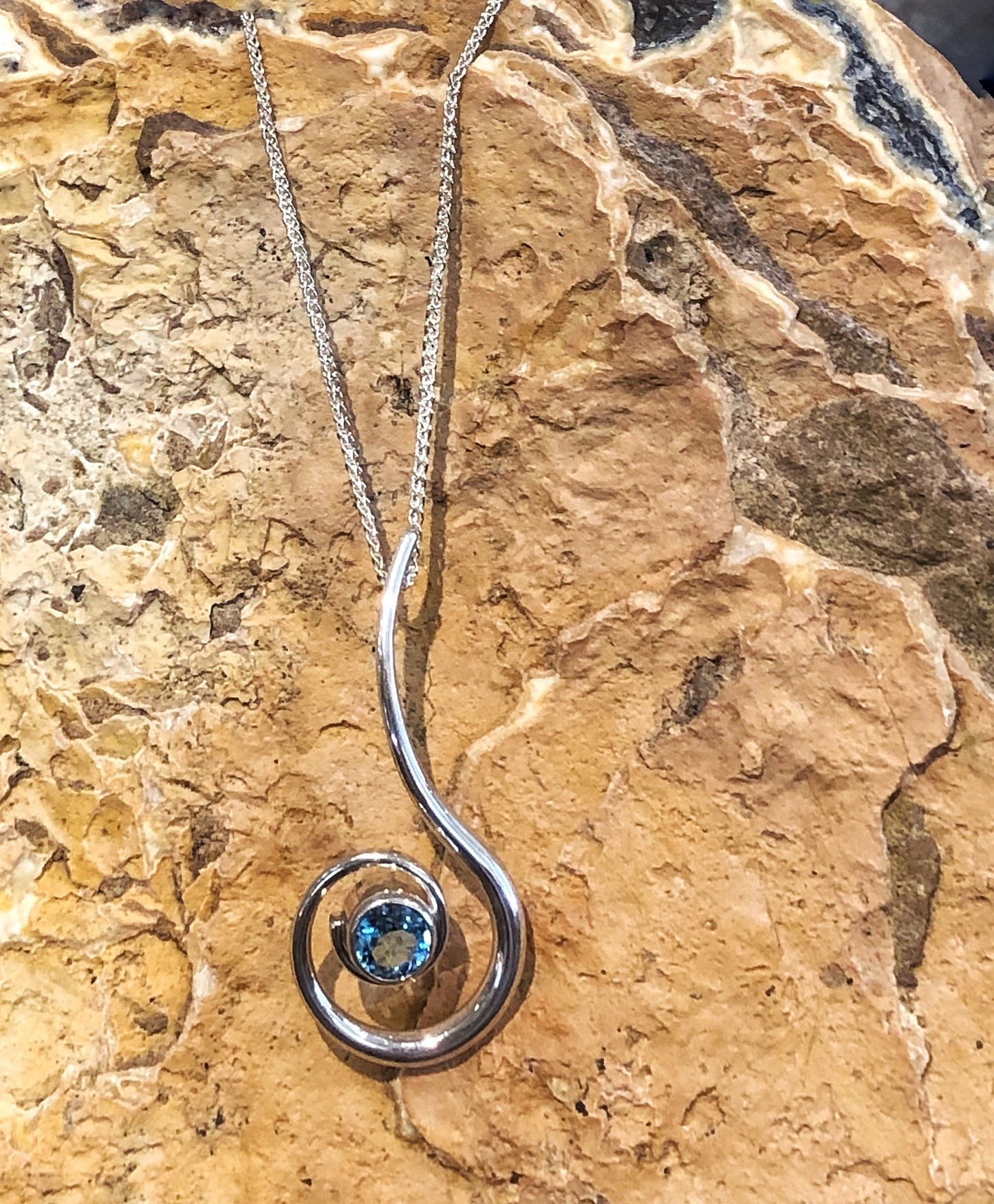 Photo of "Dancing Clef" Necklace in a decorative scene, designed by , available at Plumb Gold & Plumb Silver