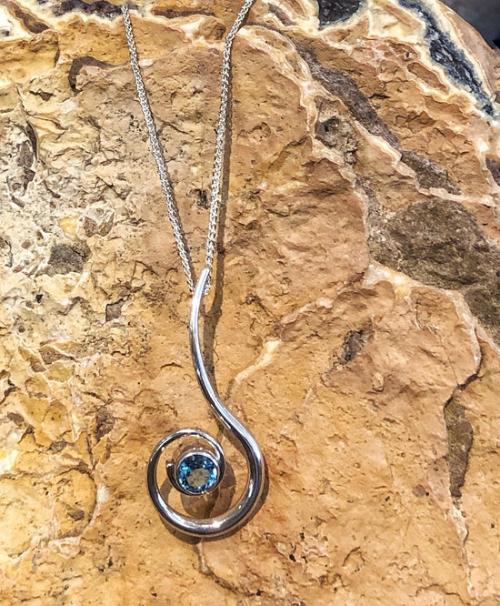 Photo of "Dancing Clef" Necklace in a decorative scene, designed by , available at Plumb Gold & Plumb Silver