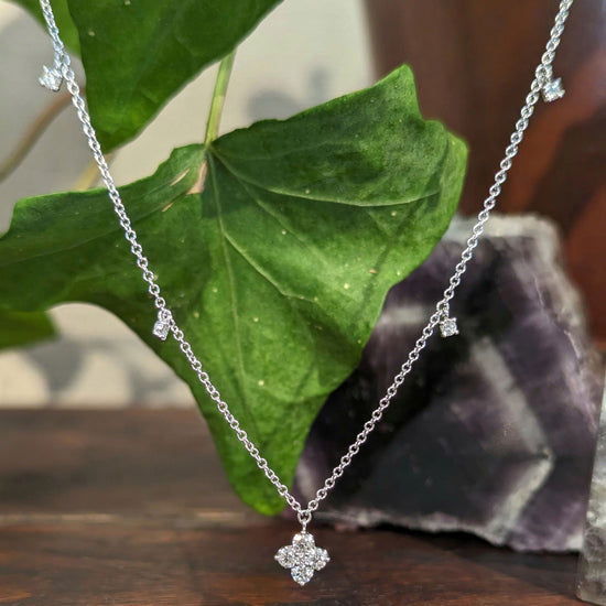 Photo of Dancing Diamond Quatrefoil Necklace in a decorative scene, designed by , available at Plumb Gold & Plumb Silver
