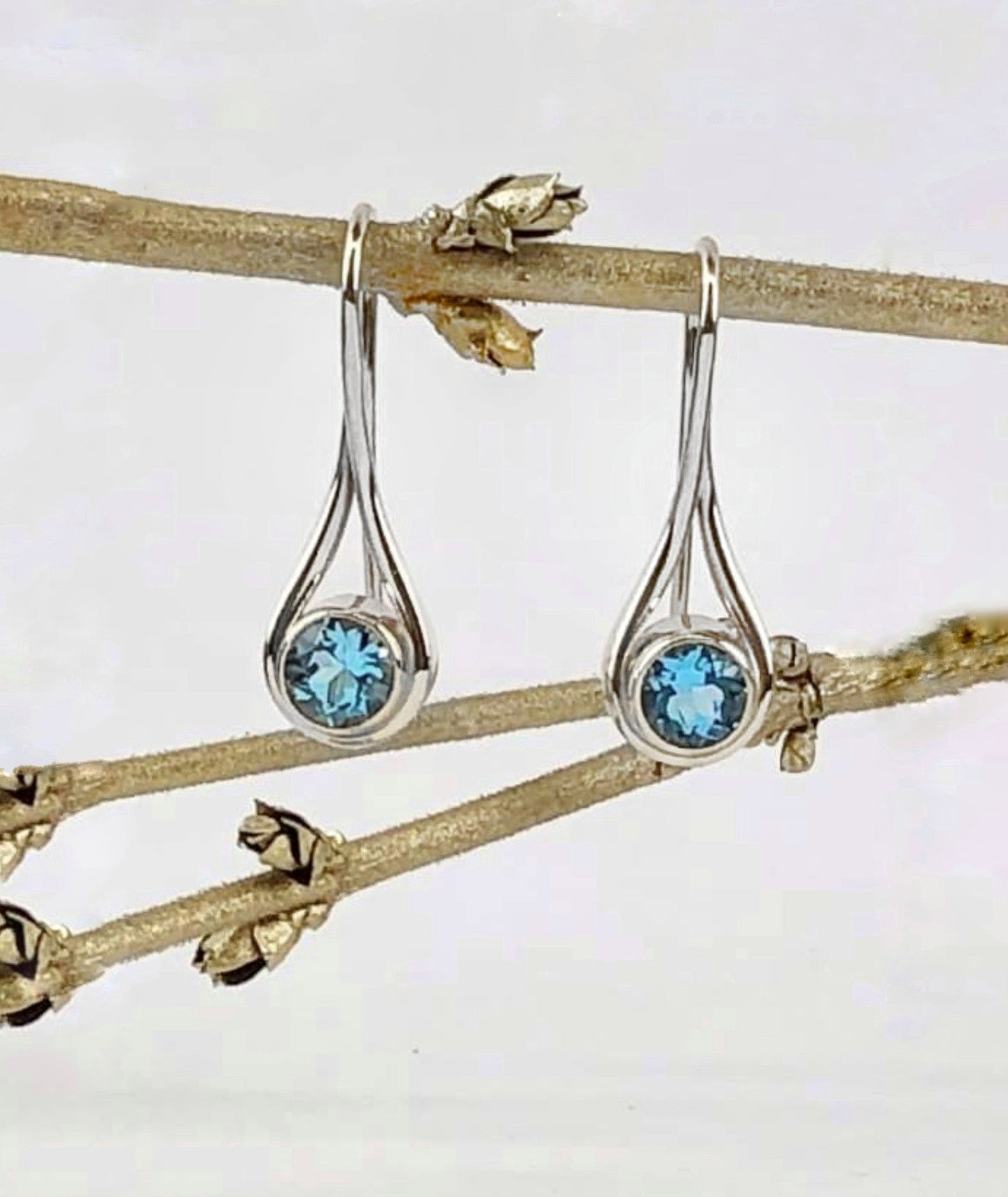 Photo of "Desire" Earrings in a decorative scene, designed by , available at Plumb Gold & Plumb Silver