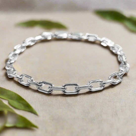 Photo of Diamond-cut oval cable bracelet in a decorative scene, designed by , available at Plumb Gold & Plumb Silver