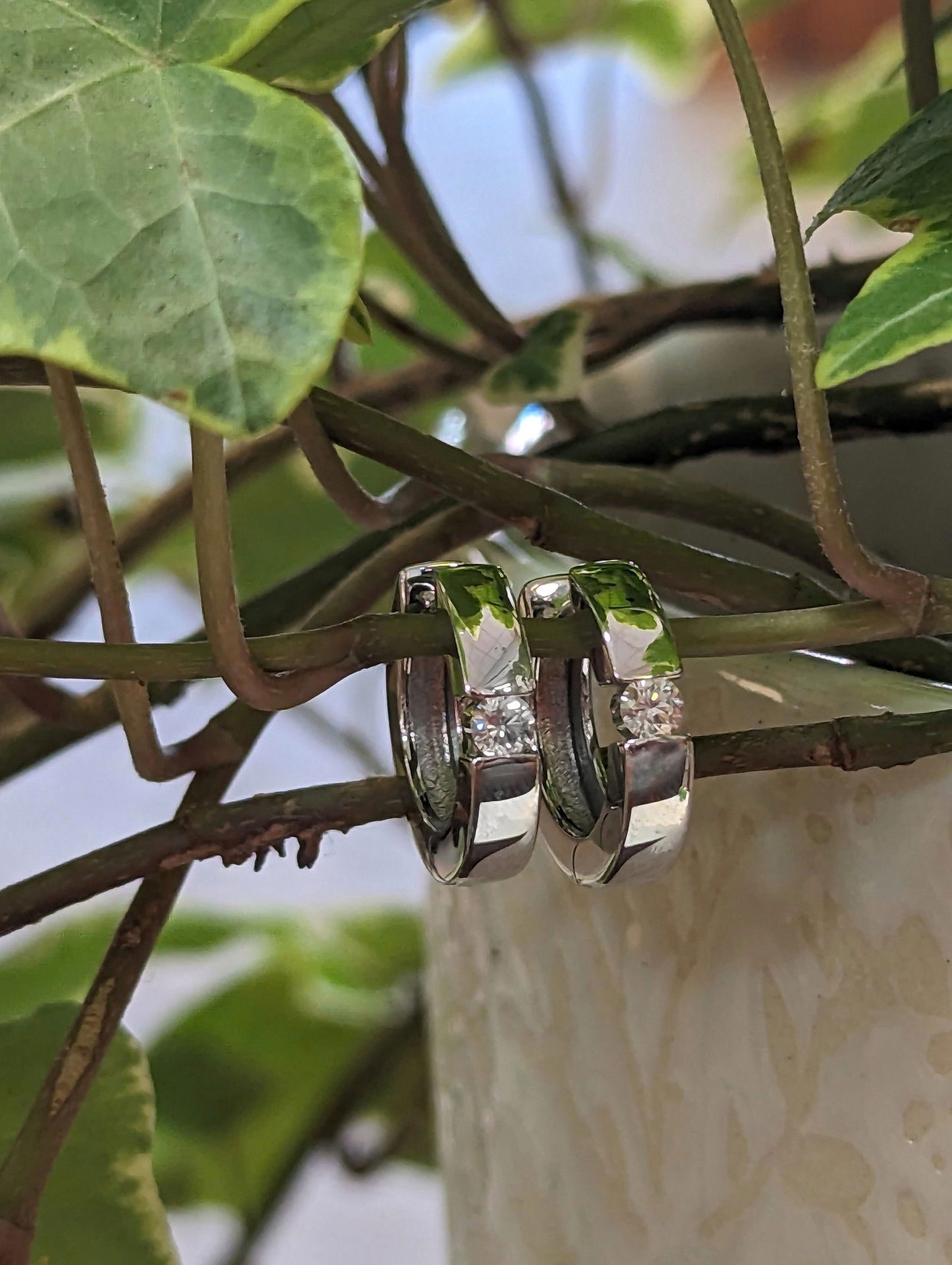 Photo of Diamond Accented Huggie Hoops in a decorative scene, designed by , available at Plumb Gold & Plumb Silver