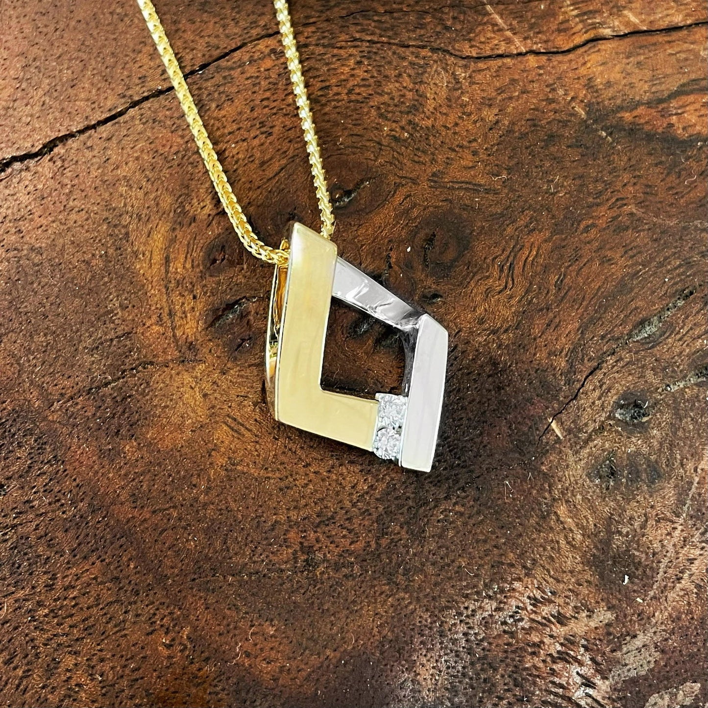 Photo of Diamond Kite Pendant in a decorative scene, designed by , available at Plumb Gold & Plumb Silver