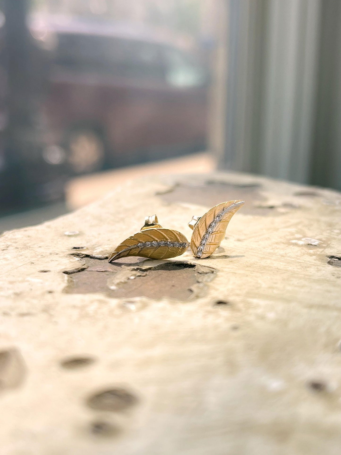 Photo of Diamond Leaf Studs in a decorative scene, designed by , available at Plumb Gold & Plumb Silver