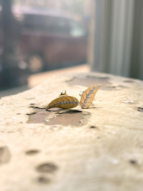 Photo of Diamond Leaf Studs in a decorative scene, designed by , available at Plumb Gold & Plumb Silver