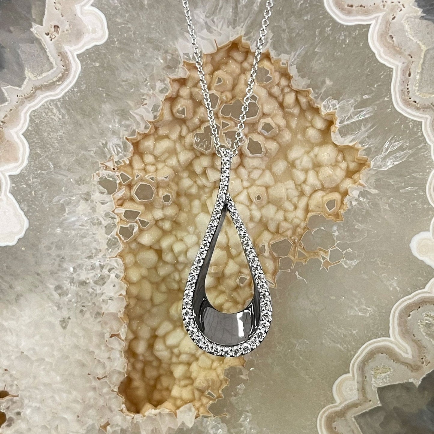 Photo of Diamond Teardrop Necklace in a decorative scene, designed by , available at Plumb Gold & Plumb Silver