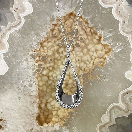 Photo of Diamond Teardrop Necklace in a decorative scene, designed by , available at Plumb Gold & Plumb Silver