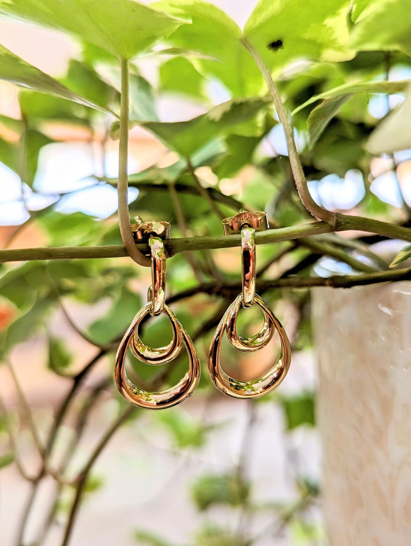Photo of Double Oval Dangle Earrings in a decorative scene, designed by , available at Plumb Gold & Plumb Silver