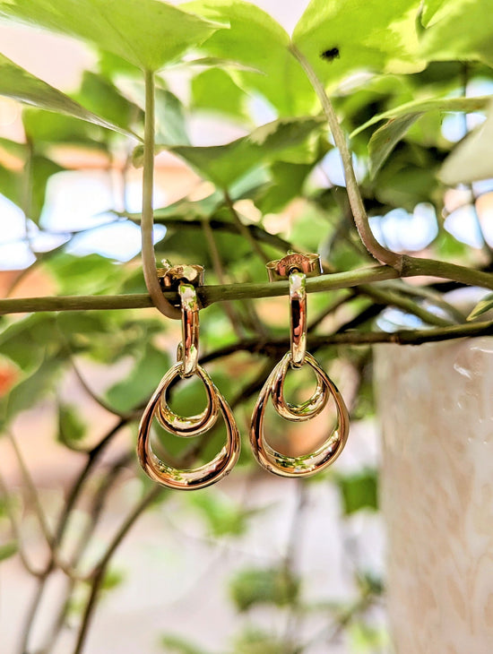 Photo of Double Oval Dangle Earrings in a decorative scene, designed by , available at Plumb Gold & Plumb Silver
