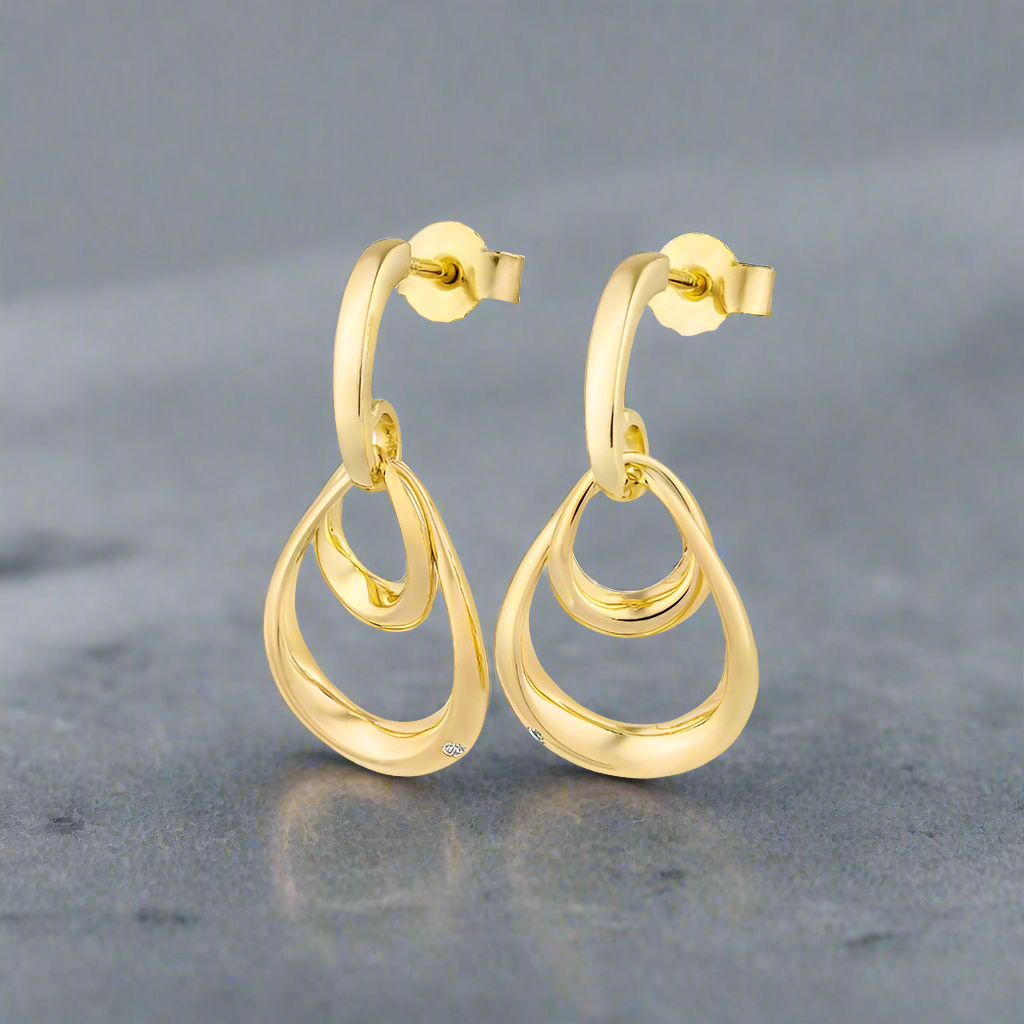 Photo of Double Oval Dangle Earrings in a decorative scene, designed by , available at Plumb Gold & Plumb Silver