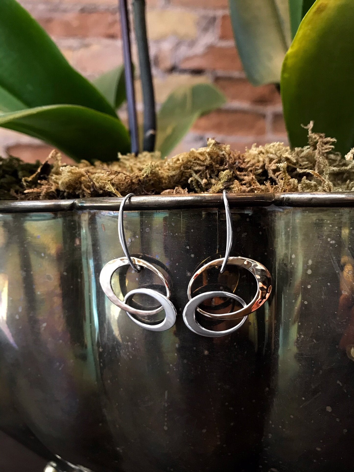 Photo of EL Designs "Entwined Elegance" Two-Toned Loop Earrings in a decorative scene, designed by , available at Plumb Gold & Plumb Silver