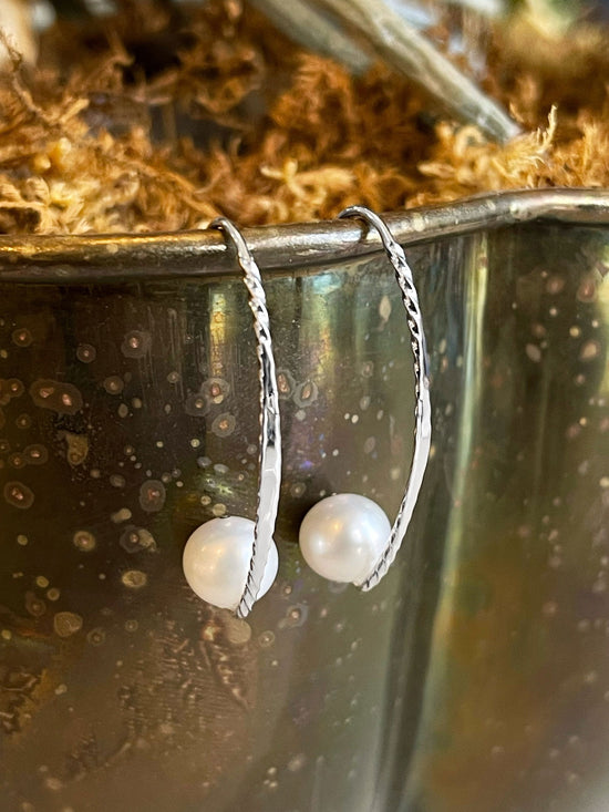 Photo of "Embrace" Earrings in a decorative scene, designed by , available at Plumb Gold & Plumb Silver