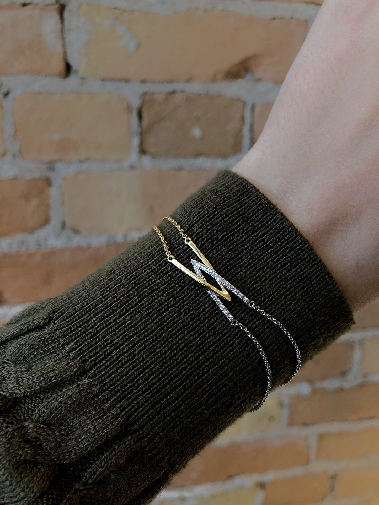 Photo of Entwining V's Bracelet in a decorative scene, designed by , available at Plumb Gold & Plumb Silver