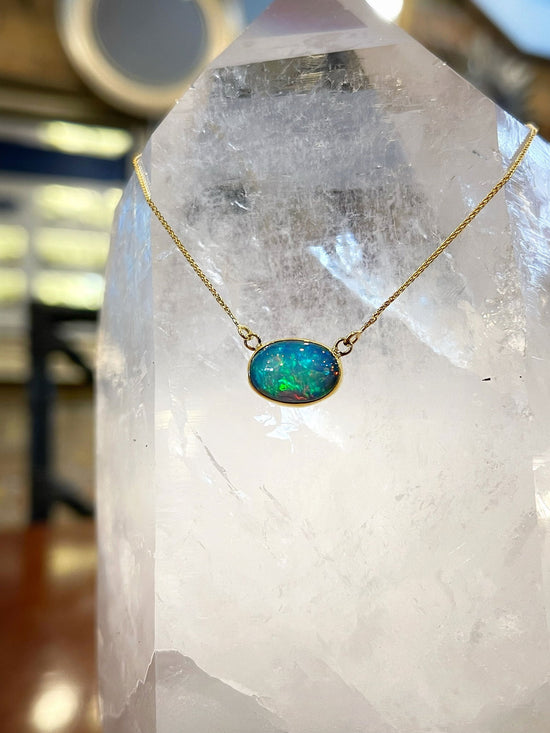 Photo of Ethiopian Opal Necklace in a decorative scene, designed by , available at Plumb Gold & Plumb Silver
