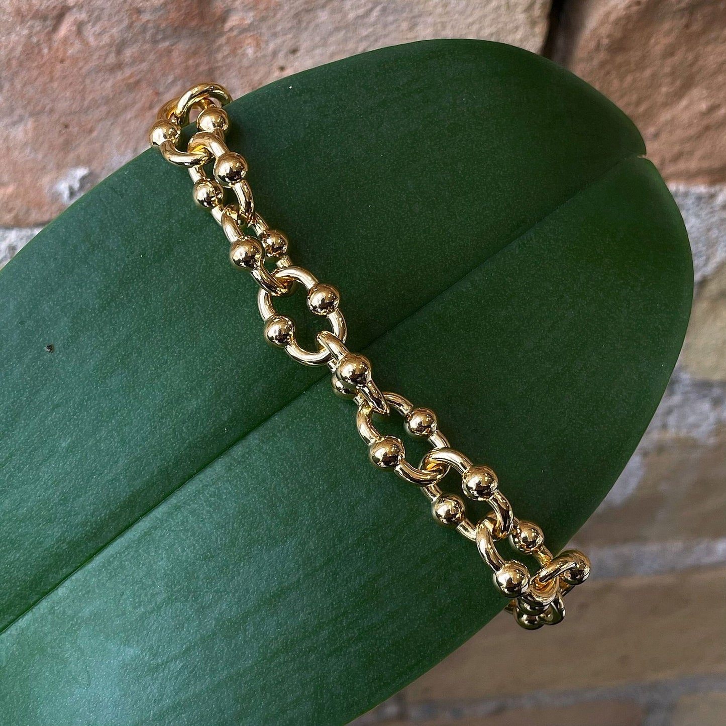Photo of Fancy Link Bracelet in a decorative scene, designed by , available at Plumb Gold & Plumb Silver