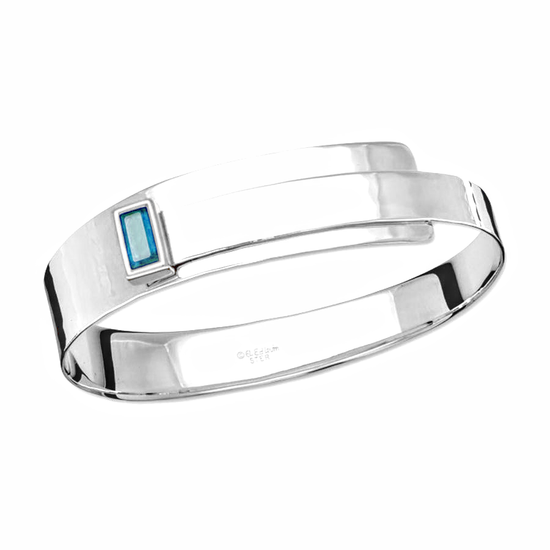Photo of "Fifth Ave" Bangle in a decorative scene, designed by , available at Plumb Gold & Plumb Silver
