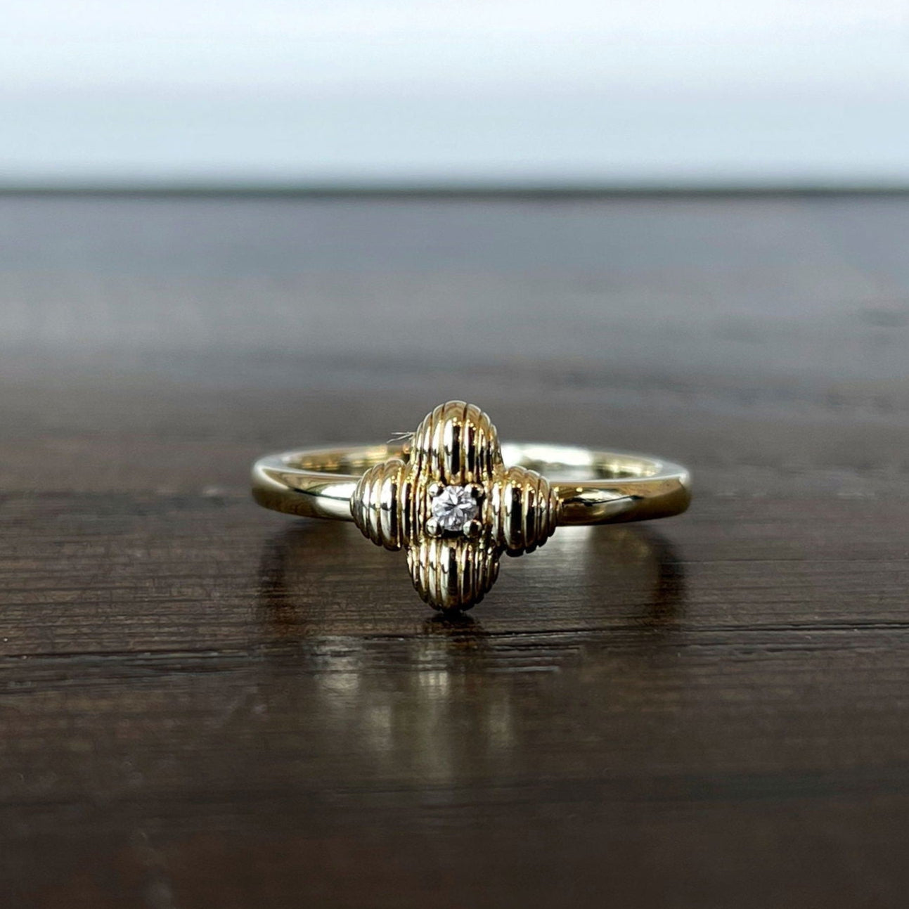 Photo of Four Leaf Ring in a decorative scene, designed by , available at Plumb Gold & Plumb Silver